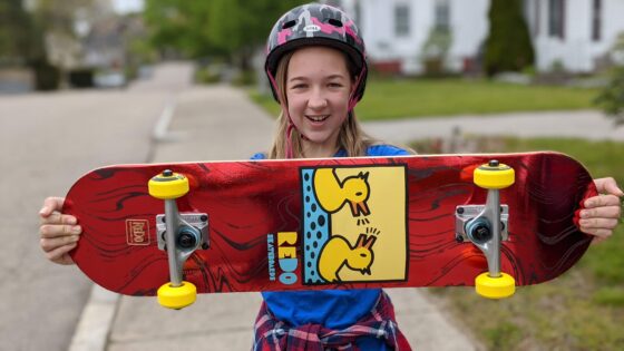 Eva holding the Eye Candy Pop Barking Ducks skateboard