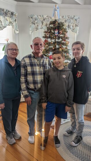 kids with the tree and grandparents